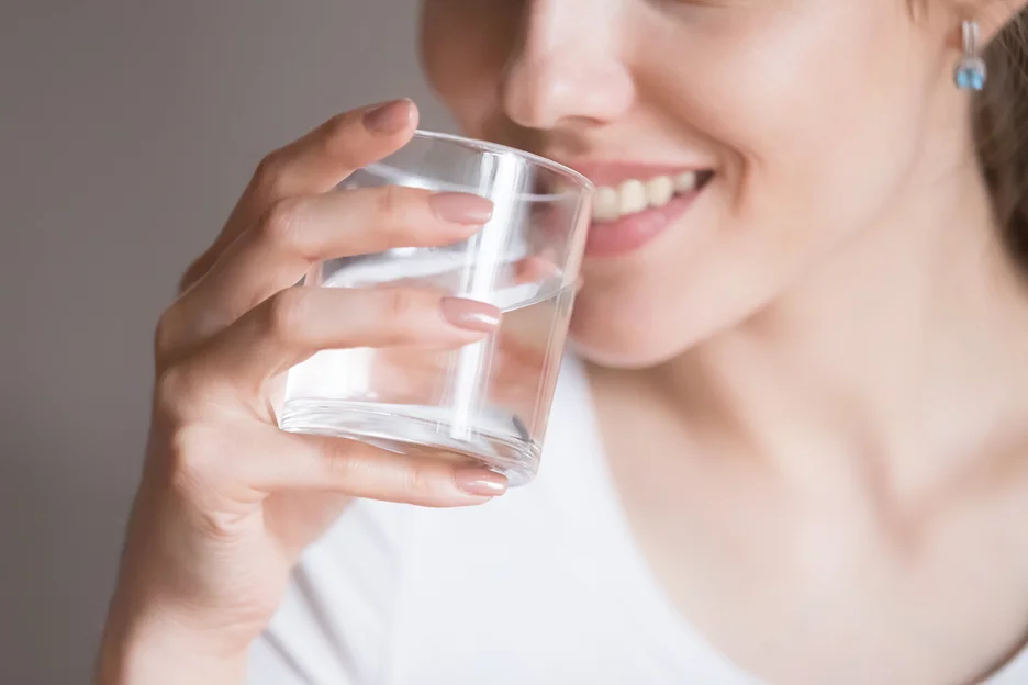 a woman drinks a glass of water
