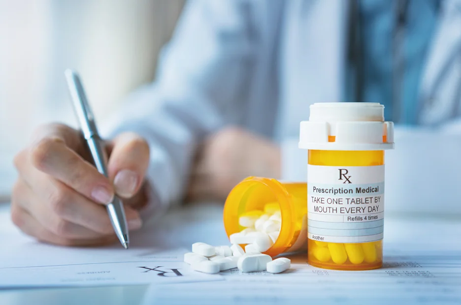 A doctor providing aftercare with a bottle of pills for brachioplasty recovery.