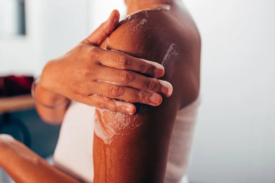 A woman is washing her arm to avoid problems before brachioplasty surgery.