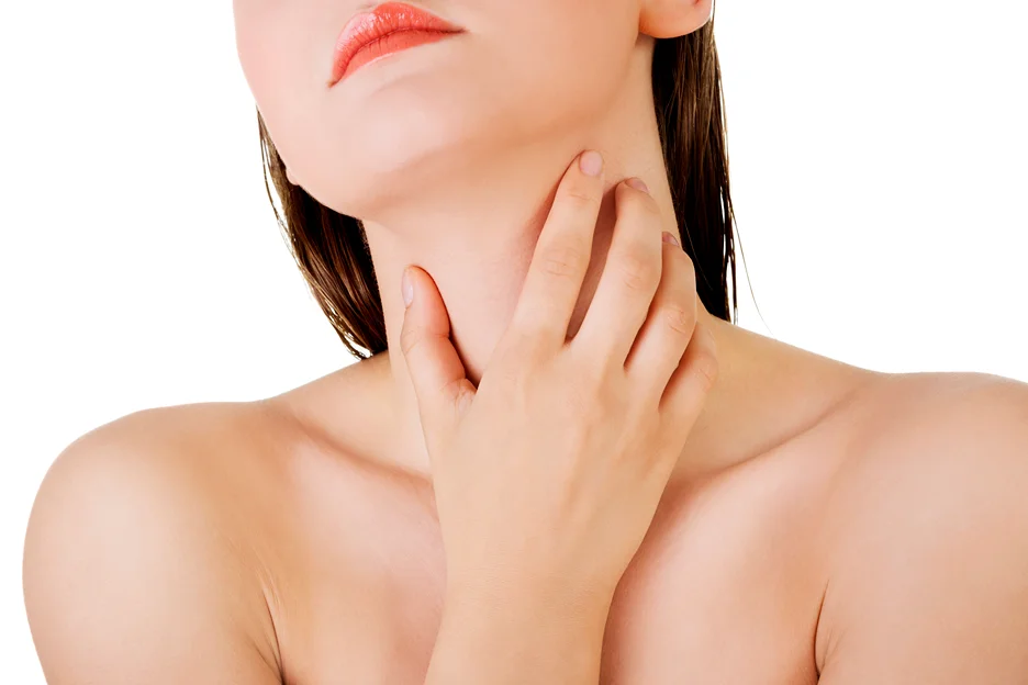 A woman with her hand gently cradling her neck.