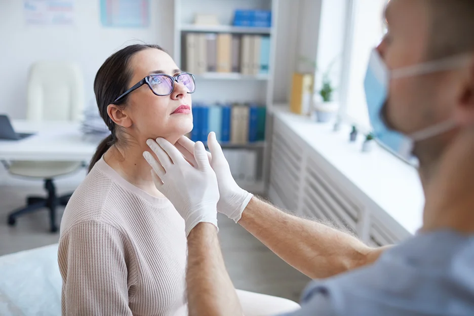 A woman is having her neck examined by a doctor, potentially assessing the neck bands.