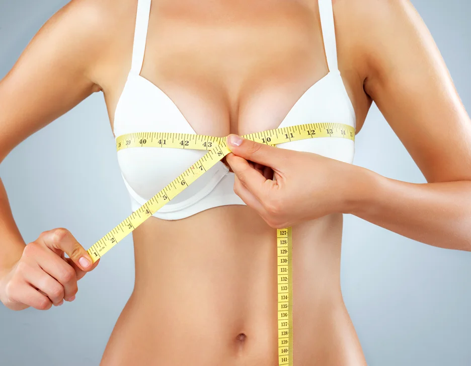 A Woman Measuring Her Breast After Breast Augmentation