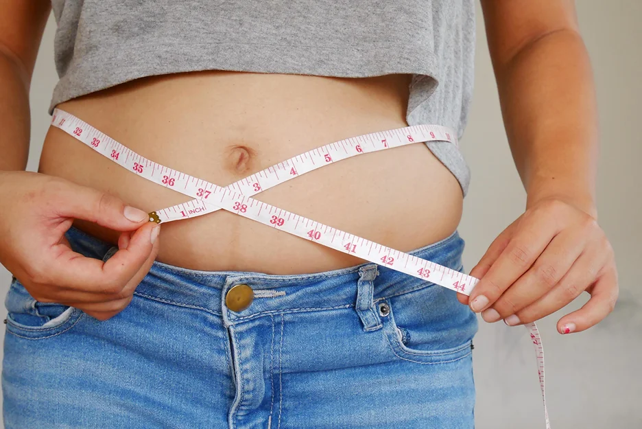A Woman Measuring her Belly Fat